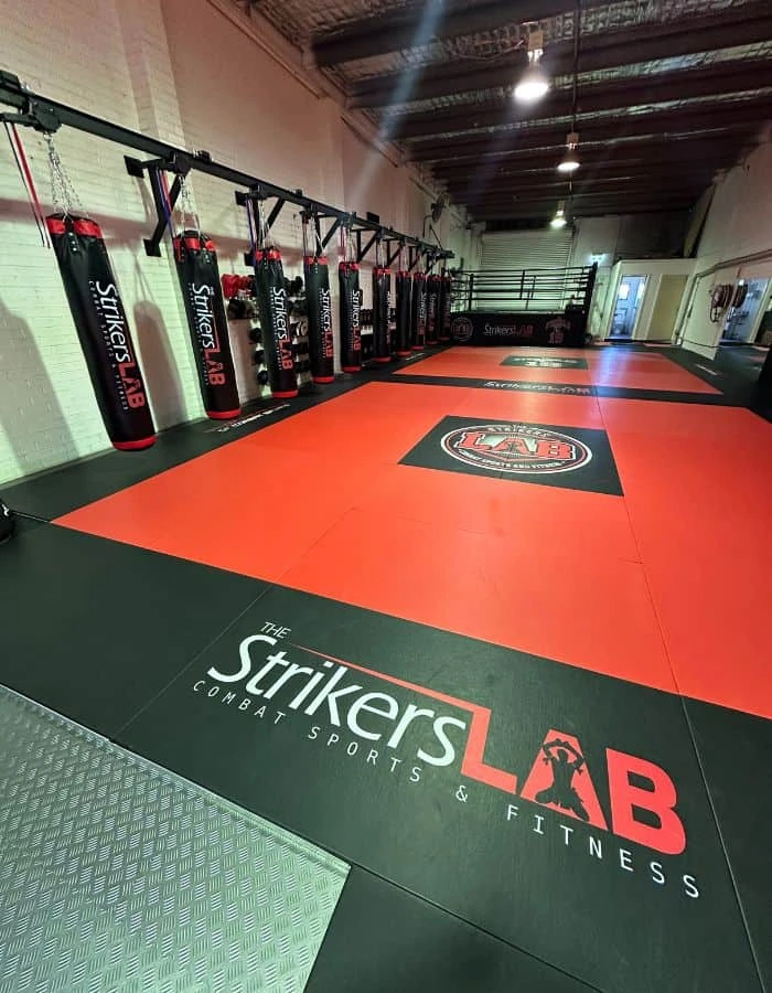 The Strikers Lab gym interior with training equipment and members training